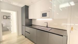 a kitchen with white cabinets and a sink at Eduardo Lucena Córdoba Center in Córdoba