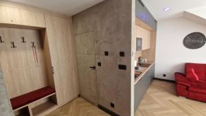 Una habitación con una puerta corrediza y un sofá rojo. en Kropla w morzu 12, en Darłowo