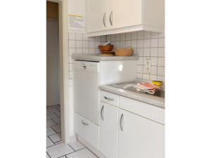 een witte keuken met witte kasten en een spoelbak bij Fewo 91 WHG C 25 in Burhave in Burhave