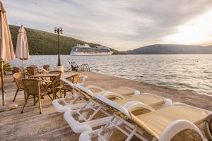 a group of chairs and tables and a cruise ship at Apartments Batricevic in Herceg-Novi