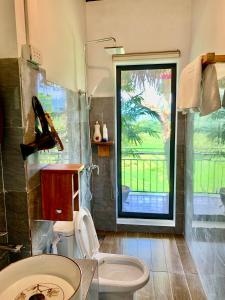 a bathroom with a toilet and a window at Puluong Aroma in Lũng Tiềm +77 photos