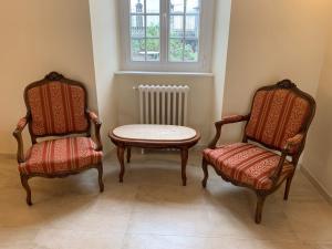a room with two chairs and a table and a window at Maison Geze in Navarrenx