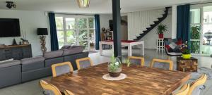 un soggiorno con tavolo e sedie in legno di La Villa Blanche - 18 personnes a Pénestin