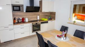 a kitchen with a dining table and a kitchen with a orange car at Apartma TOBI in Bovec