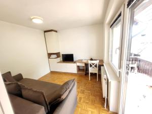 a living room with a couch and a desk at Bella Bela Apartments 18A in Bled +18 photos