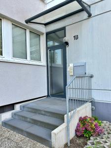 a front door of a house with stairs and flowers at Wohnung in Monheim am Rhein in Monheim
