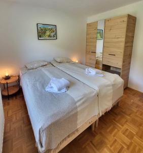 a bedroom with a large bed with towels on it at Bella Bela Apartments 18A in Bled