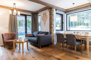 a dining room and living room with a table and chairs at Apartamenty Małe Żywczańskie Lux&SPA in Zakopane