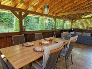 a dining room with a wooden table and chairs at Casa Alina in Arpaşu de Sus