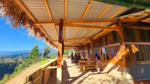 a wooden building with people standing outside of it at Nature Homestay Mù Cang Chải in Mù Cang Chải +42 photos