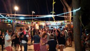 a crowd of people standing around a nightclub at night at Camping Village Il Sole in Marina di Grosseto +91 photos