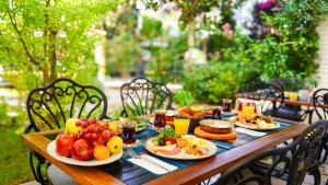 a wooden table with plates of food on it at Tuzla Garden Hotel & Spa in Tuzla