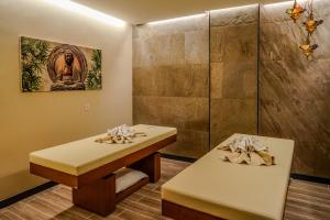two tables in a room with a wall at Tuzla Garden Hotel & Spa in Tuzla