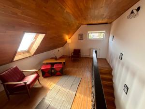 an attic room with a couch and a table at Chill Garden Füred in Balatonfüred