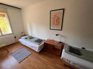 a room with two beds and a table and a window at Chill Garden Füred in Balatonfüred