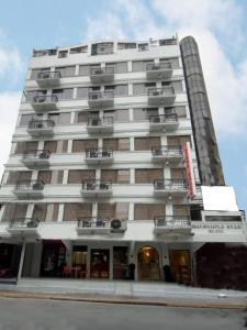a tall white building with balconies at Stone House Hotel Manila in Manila