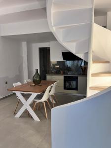 a kitchen and dining room with a table and chairs at Ραστώνη in Tolo +14 photos