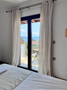 a bedroom with a bed and a window with a view at Ραστώνη in Tolo