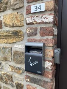 a brick wall with a pay meter on it at Le P'tit Padré in Jalhay