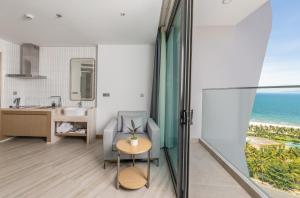 a bathroom with a chair and a sink and the ocean at Awaken Da Nang Hotel in Danang