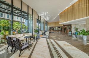 an office lobby with tables and chairs and windows at Awaken Da Nang Hotel in Danang