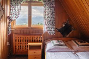 a small bedroom with a bed and a window at Willa Szafran - pokoje in Zakopane