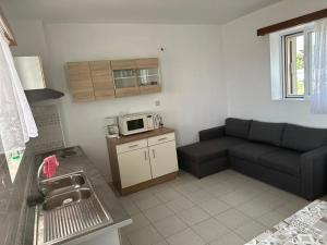 a living room with a couch and a microwave at KakLeCharaki in Haraki