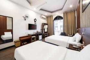 a hotel room with two beds and a tv at A25 Hotel - 12 Liên Trì in Hanoi