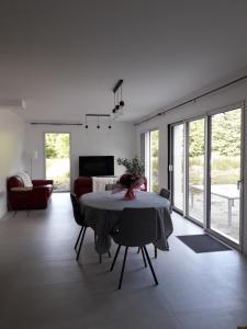 a living room with a table and a couch at Maison du soleil levant in Plescop