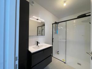a bathroom with a sink and a glass shower at Maison du soleil levant in Plescop