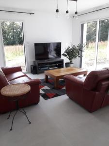a living room with couches and a coffee table at Maison du soleil levant in Plescop