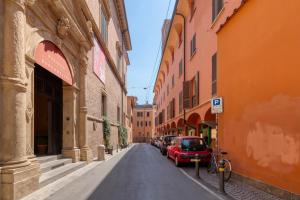 an alley with cars parked on a street between buildings at Carbonara Palace 2 - Luxury Comfort under Medieval Towers in Bologna