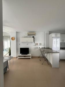 a kitchen and living room with a table and a television at Turquesa 8 in Zahara de los Atunes