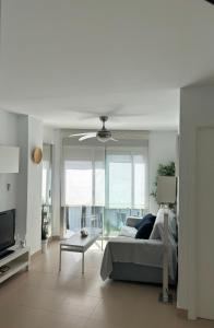 a living room with a couch and a ceiling fan at Turquesa 8 in Zahara de los Atunes