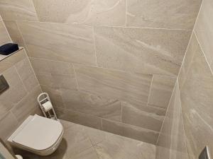 ein Badezimmer mit Toilette und gefliester Wand in der Unterkunft NEW Apartment - O2 Arena Prague with parking in Prag