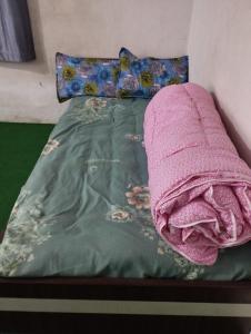 un letto con una coperta rosa sopra di Tharu COOP Homestay in Sauraha -Chitwan a Sauraha
