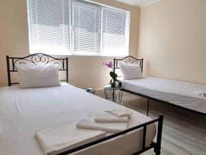 Un dormitorio con dos camas y una ventana en House Vesela, en Balchik