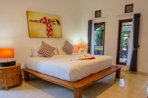 Un dormitorio con una gran cama blanca y dos lámparas. en VIlla Dafne, en Seminyak