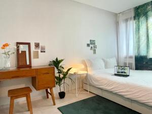 a bedroom with a bed and a desk with a laptop on it at sentimental in Busan