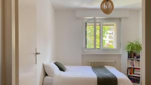 PullyChambre au bord du lac Léman的带床和窗户的卧室