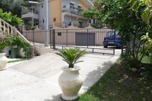 a large white vase with a plant in it on a sidewalk at Apartmani Janosevic in Sutomore
