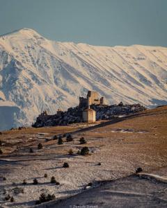 a building on a hill with a mountain in the background at La finestra sul cortile by TraMonti Apartments in LʼAquila