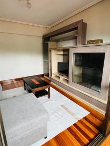 a living room with a couch and a flat screen tv at Muskiz Retreat, playa 5 mins, WIFI gratis in Muskiz
