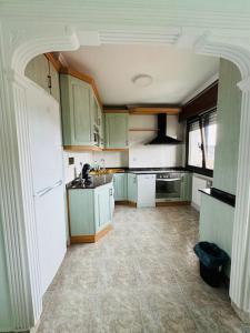 a kitchen with green cabinets and a white refrigerator at Muskiz Retreat, playa 5 mins, WIFI gratis in Muskiz