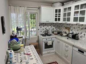 a kitchen with white cabinets and a stove at KAAN Göl Evi Konaklama in Kocaeli