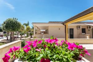 a house with pink flowers in front of it at La Pineta Residence in Otranto