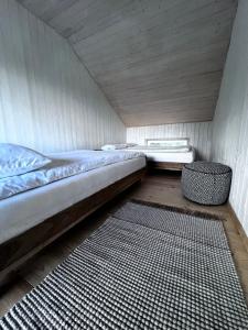 a small room with a bed and a rug at Homestead Ajerai in Valkininkai
