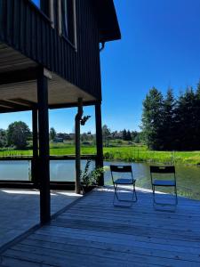 two chairs sitting on a dock next to a lake at Homestead Ajerai in Valkininkai