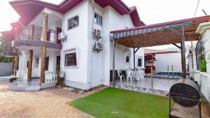 a house with a green lawn in front of it at MICASO Guest House in Limbe