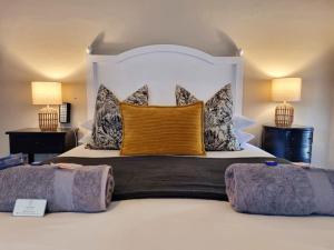a bedroom with a large white bed with two lamps at The Merino Guest House in Beaufort West